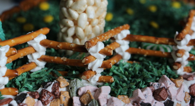 Gingerbread fence and forest behind (with winter aconite flowers of yellow m&ms).